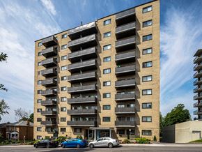 Ottawa apartment for rent - a tall apartment building with cars parked in front of it