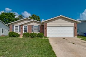 Florissant house for rent - A house with a white garage door and brick pillars.
