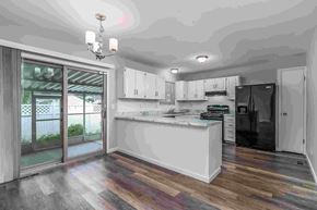 Florissant house for rent - A modern kitchen with a white island and wooden flooring.