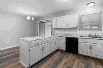 Florissant house for rent - A kitchen with white cabinets and a black dishwasher.