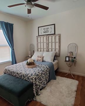 Edinburg apartment for rent - a bedroom with a bed and a blue and white bedspread and a ceiling fan