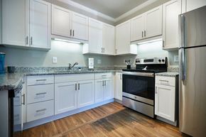 Lexington apartment for rent - A kitchen with white cabinets and a granite countertop.
