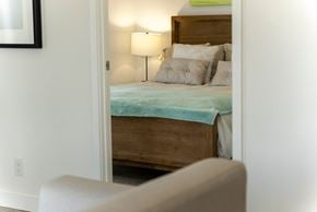 Oshawa apartment for rent - a bedroom with a bed and a chair and a lamp