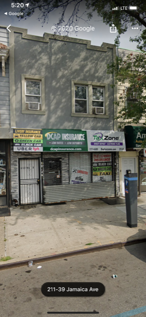 Queens apartment for rent - A street view of a building with a closed shutter and a sign that reads "211-39 Jamaica Ave".