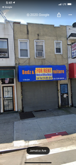 Queens apartment for rent - A street view of a building with a closed shutter and a sign that says "Bedz & For Rent".