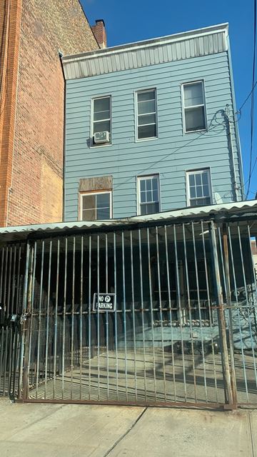 The Bronx apartment for rent - a blue building with a fence in front of it