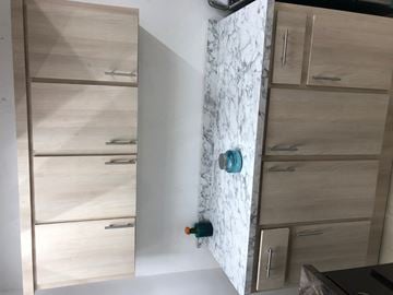 San Juan apartment for rent - a kitchen with wooden cabinets and a white wall with a door with a blue knob