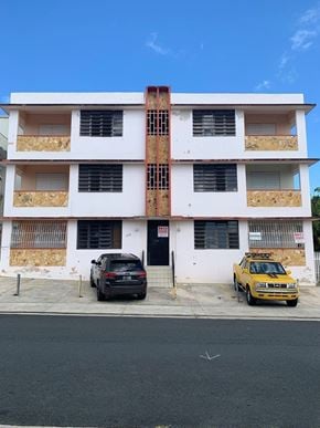 San Juan apartment for rent - an apartment building with two cars parked in front of it