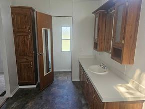 Shawnee house for rent - A bathroom with a sink and wooden cabinets.