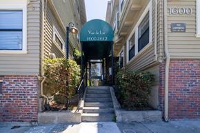 Oakland apartment for rent - A green sign that says "Vue de Loc 1600-1612" is in front of a building.