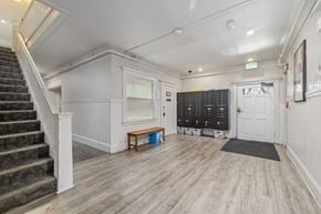 Oakland apartment for rent - A room with a staircase on the left and a white door on the right.