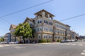 Oakland apartment for rent - A large, multi-story building with a mix of beige and blue colors dominates the scene.