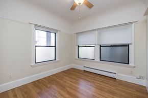 Oakland apartment for rent - A room with a ceiling fan and a window with blinds.