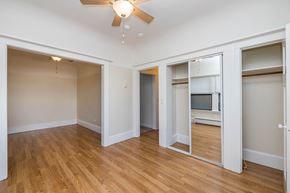 Oakland apartment for rent - A room with a ceiling fan and wooden flooring.