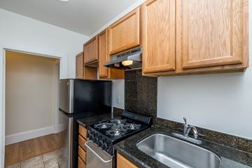 Oakland apartment for rent - A kitchen with wooden cabinets and black appliances.