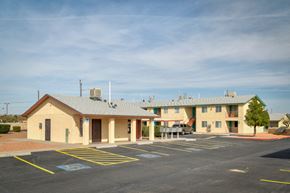 El Paso apartment for rent - A parking lot in front of a building with a yellow and blue painted parking space.