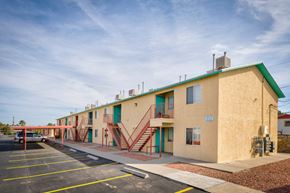 El Paso apartment for rent - A building with a green roof and a parking lot in front.