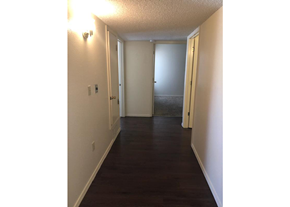 El Paso apartment for rent - A hallway with a door on the right and a light on the wall.