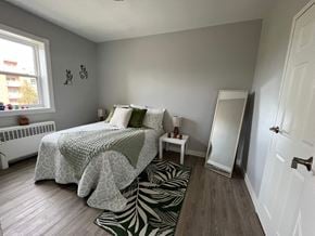 Windsor apartment for rent - A bedroom with a bed, a small table, and a zebra rug.
