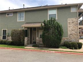 Round Rock apartment for rent - A green house with a stone pillar on the front porch.