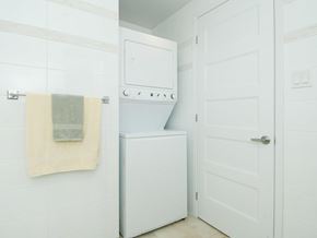 Ottawa apartment for rent - A white bathroom with a towel hanging on the wall and a white door.