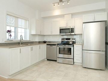 Ottawa apartment for rent - a white kitchen with stainless steel appliances and white cabinets