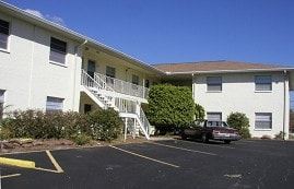 Clearwater apartment for rent - A car is parked in a parking lot in front of a white building.