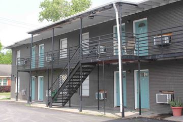 Houston apartment for rent - a gray building with stairs and a balcony