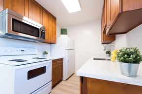 Sunnyvale apartment for rent - a kitchen with white appliances and wooden cabinets
