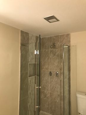 Baltimore apartment for rent - A shower stall with a glass door and a tiled wall.