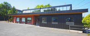 Portland apartment for rent - the front of a building with a black facade and orange roof