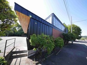 Portland apartment for rent - the side of a building with a black facade and trees
