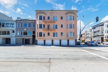 San Francisco apartment for rent - A street view of a building with a parking lot in front.