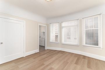 San Francisco apartment for rent - A room with a white door, a window with blinds, and a washing machine.