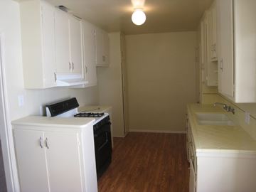 Valley Village apartment for rent - an empty kitchen with white cabinets and a stove