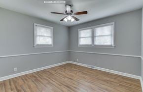 Mauldin house for rent - an empty room with a ceiling fan and two windows