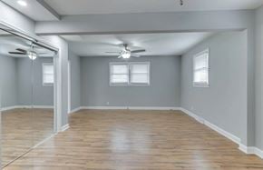Mauldin house for rent - an empty living room with wood floors and a ceiling fan