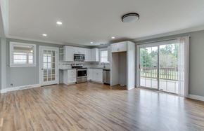 Mauldin house for rent - an empty living room with a kitchen and a sliding glass door