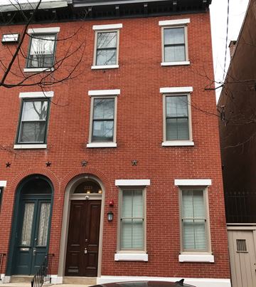 Philadelphia apartment for rent - a red brick house with a black door and windows