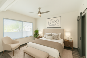 Nashville apartment for rent - A bedroom with a large bed, a chair, and a ceiling fan.