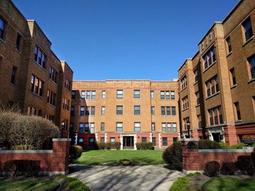 Oak Park apartment for rent - a large brick building with a green yard in front of it