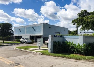 Pompano Beach apartment for rent - A white building with a grey car parked in front.