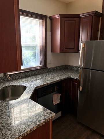 Evanston apartment for rent - A kitchen with a granite counter top and a stainless steel refrigerator.