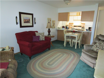 Payette apartment for rent - a living room with a red couch and a rug in front of a kitchen