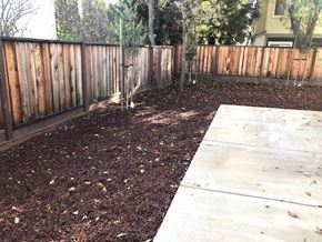 Gilroy apartment for rent - a backyard with a wooden fence and a sidewalk