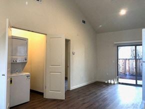 Gilroy apartment for rent - an empty living room with a refrigerator and a door