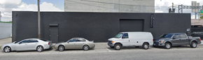 Miami apartment for rent - Three cars parked in front of a black building.
