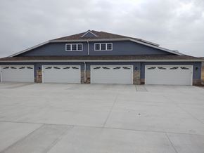 Belgium apartment for rent - the front of a garage with three white garage doors