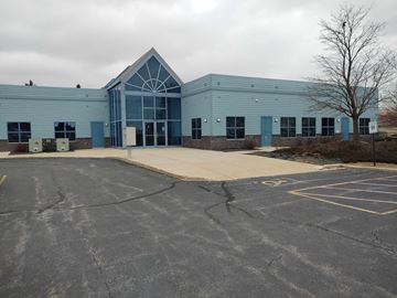 Port Washington apartment for rent - the front of a blue building with a parking lot