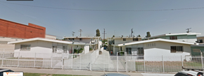 Inglewood apartment for rent - A white building with a red brick building in the background.